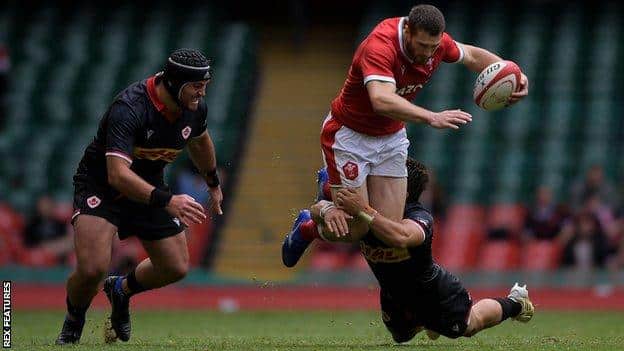 Jonah Holmes of Wales is tackled by Ross Braude of Canada